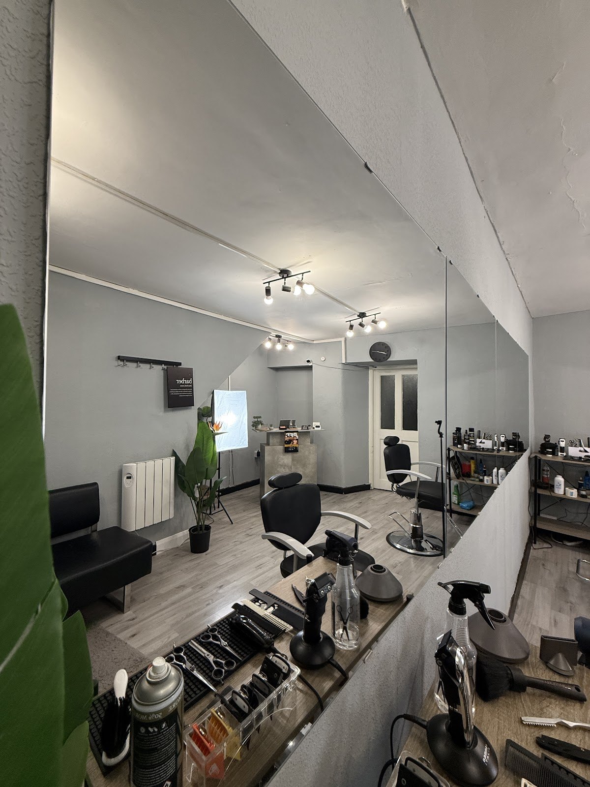 Inside HairLab. Athlone: wooden stations, black chairs, clippers on the bench and the shop floor in the mirror